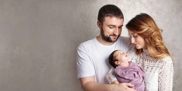 Mujer y hombre sosteniendo a un recién nacido. Mamá, papá y bebé. Retrato de —  Fotos de Stock