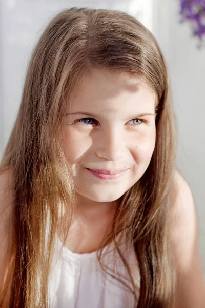 Portrait of pretty  little emotion girl  among violet flowers.Cl — Stock Photo, Image