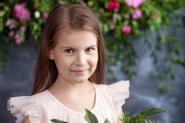 Bir buket çiçek ile portre sevimli küçük kız. Lo