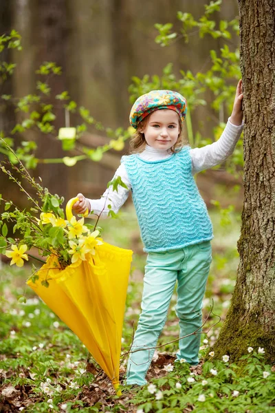 Petite fille mignonne avec des fleurs de narcisse dans un jardin de printemps. Chi ! — Photo