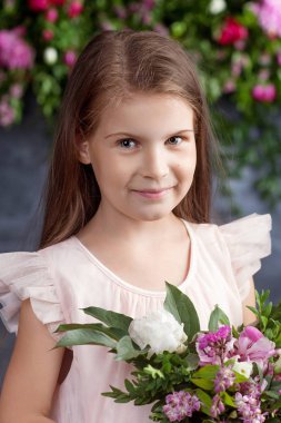 Bir buket çiçek ile portre sevimli küçük kız. Lo