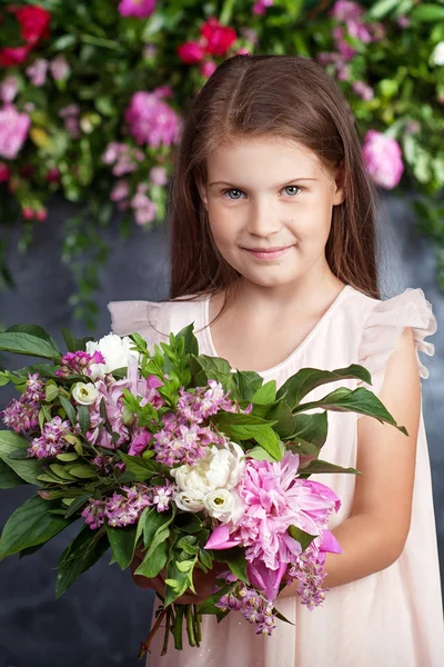 Portrait de la charmante petite fille avec un bouquet de fleurs. Lo ! — Photo