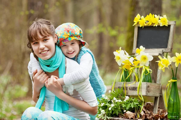 Portrait of two sisters  in the spring forest. Smiling cute sist