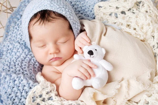 Sweet newborn baby sleeps in a basket. Beautiful newborn boy wit — Stock Photo, Image