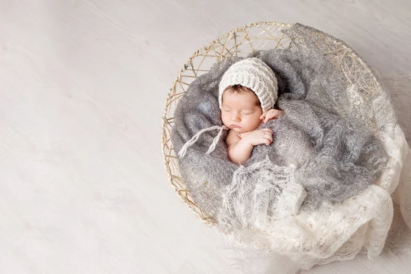 Beautiful little newborn baby 2 weeks sleeping in a basket with — Stock Photo, Image