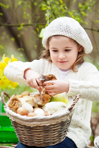 Bonne petite fille avec un panier de petits poulets assis en plein air — Photo