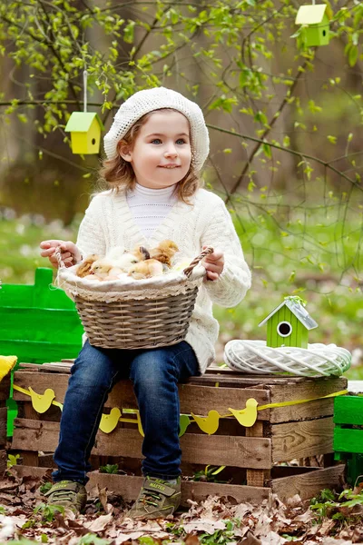 Šťastná holčička s řadou malých kuřat sedí outdoo — Stock fotografie