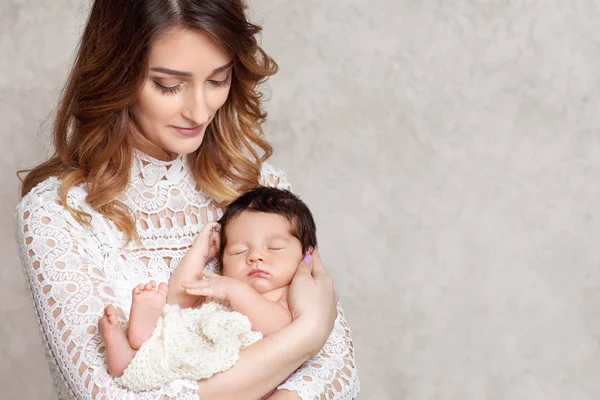 Hübsche Frau hält ein neugeborenes Baby im Arm. — Stockfoto