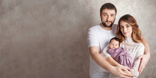 Mujer y hombre sosteniendo a un recién nacido. Mamá, papá y bebé. Retrato de —  Fotos de Stock