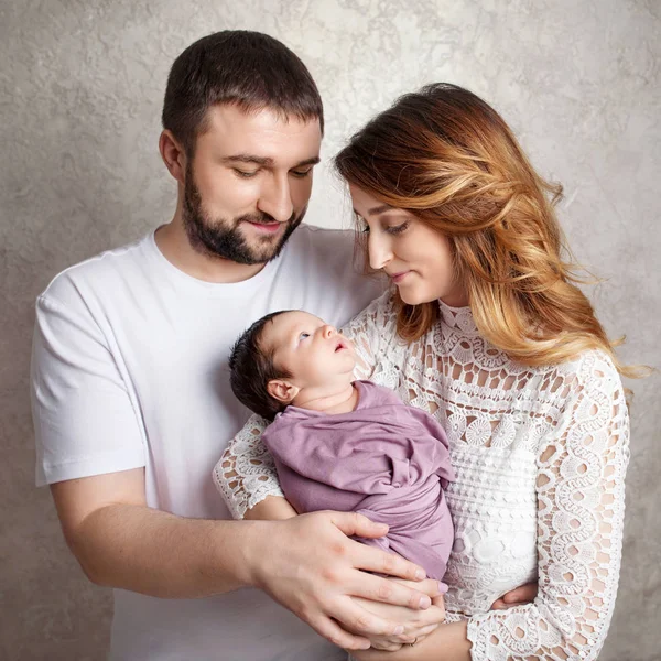 Kadın ve yeni doğmuş bir bebek tutan adam. Anne, baba ve bebek. Portresi