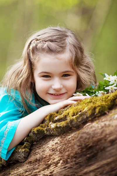 Krásná malá dívka v modrých šatech, procházky v lese na jaře — Stock fotografie