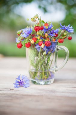 Yabani çilek ve çiçeklerden buket. Sağlıklı doğal gıda. 