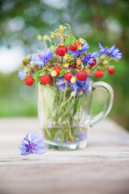 Yabani çilek ve çiçeklerden buket. Sağlıklı doğal gıda. 