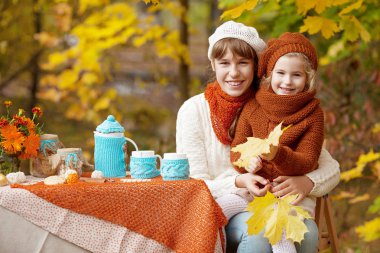 Sonbahar parkında pikniğe iki sevimli kız kardeş. Sevimli küçük kız