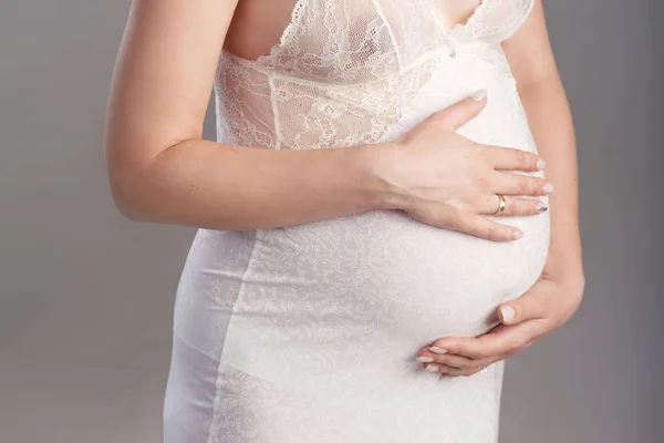 Imagen de cerca de una mujer embarazada tocándose el vientre con las manos . — Foto de Stock