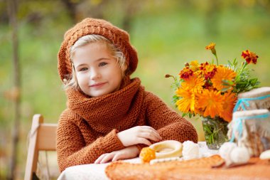 Sonbahar parkında piknikte sevimli küçük kız. Gülümseyen küçük gi