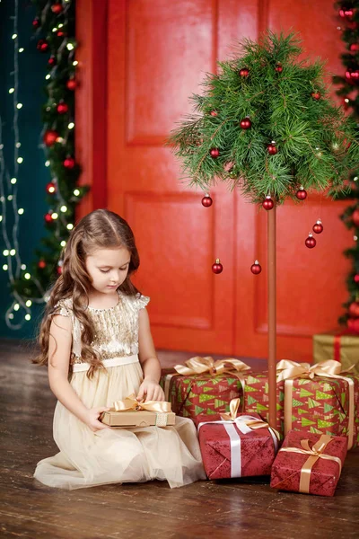 Mooi klein meisje openen van een doos van de gift van Kerstmis. Kerst een — Stockfoto