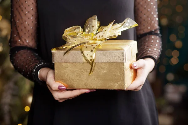 Vrouw handen Holding gouden geschenk doos. Kerstmis, Nieuwjaar, geboorte — Stockfoto