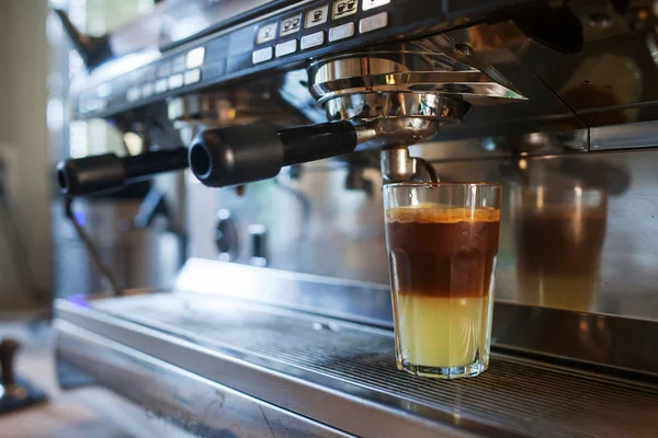 Close-up of coffee pouring from coffee machine. Professional cof