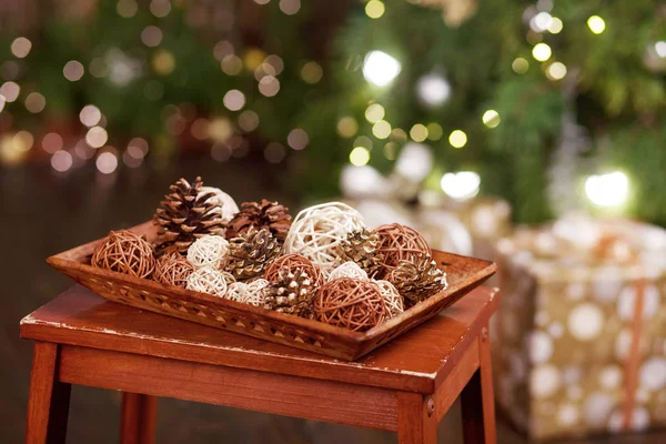 Weihnachtsdekoration. Kiefer Unebenheiten und rotierende Kugeln auf einem Holztablett auf — Stockfoto