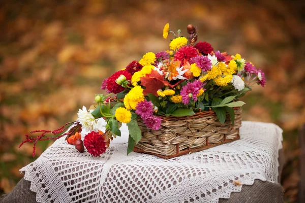 Bouquet of autumn flowers in the basket on the table in rustic s — Stock Photo, Image