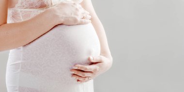 Hamile karnına kapatın. Kadın bir göbek ile bir bebek bekliyor 