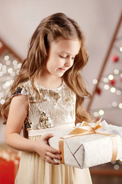 Prachtig lachend klein meisje met een kerstgeschenkdoos. Chri — Stockfoto