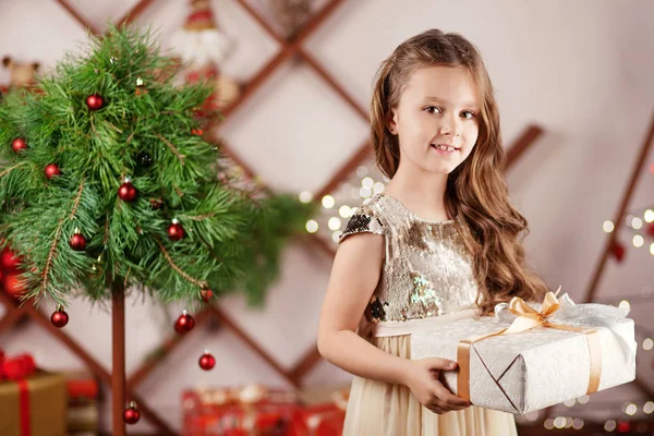 Prachtig lachend klein meisje met een kerstgeschenkdoos. Chri — Stockfoto