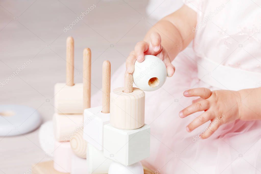 Child girl playing with a wooden toy sorter. Little cute girl wi