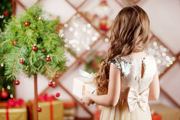 Menina bonita segurando uma caixa de presente de Natal. Natal um — Fotografia de Stock