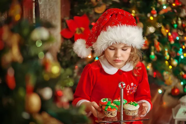 Veselé Vánoce - Malá hezká dívka v klobouku drží talíř s c — Stock fotografie
