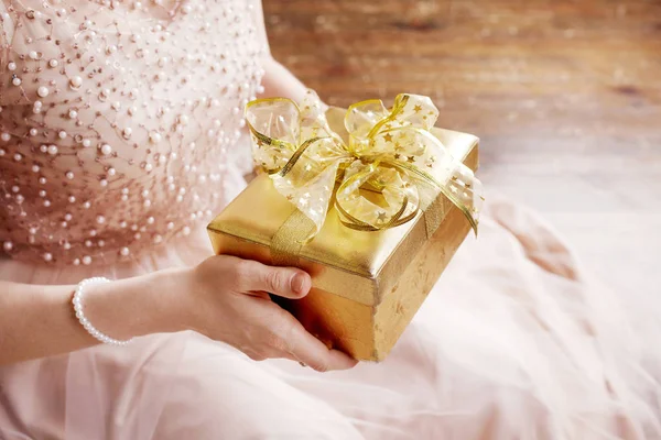 Vrouw handen Holding gouden geschenk doos. Kerstmis, Nieuwjaar, geboorte — Stockfoto