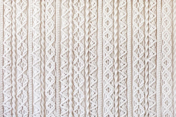 Close-up of hand made macrame texture pattern. ECO friendly modern knitting DIY natural decoration concept  in the interior. Flat lay. Handmade macrame 100% cotton. Female hobby.