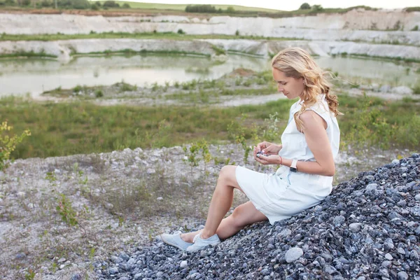 Junge Frau Sitzt Auf Einem Steinernen Hügel Vor Dem Hintergrund — Stockfoto
