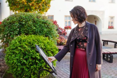 Güzel bir kadın, güneşli bir sonbahar ya da bahar gününde sokakta yürüyor. Kahverengi ceketli bir manken. Şehrin caddesindeki bir kafede kadın menüsü.