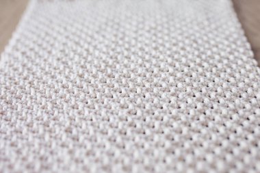 El yapımı bej makrome desenli arka plan. Makrame dokusu, ECO dostu, modern örgü. Tahta masadaki Macrame halısı