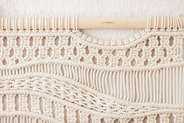 Yakın plan el yapımı makrome doku deseni. Çevre dostu modern örgü. İç mekanda doğal dekorasyon konsepti. Düz yatıyordu. El yapımı makrome% 100 pamuk. Kadın hobisi.