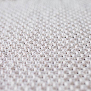 El yapımı bej makrome desenli arka plan. Makrame dokusu, ECO dostu, modern örgü. Tahta masadaki Macrame halısı