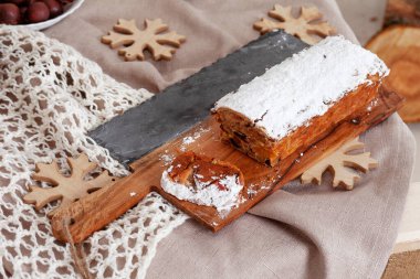 Güzel, lezzetli, ev yapımı Noel meyveli keki ahşap tahtada. Kutlama sezonu için dekorasyon malzemeleriyle birlikte.