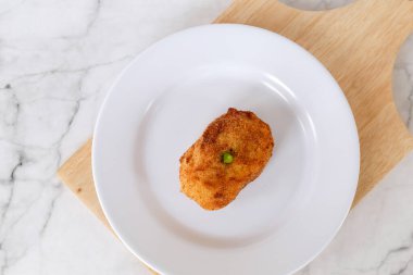 Beyaz tabakta kırmızı biberle doldurulmuş kroket patatesi. Yemek için Asya Pasta Yemekleri