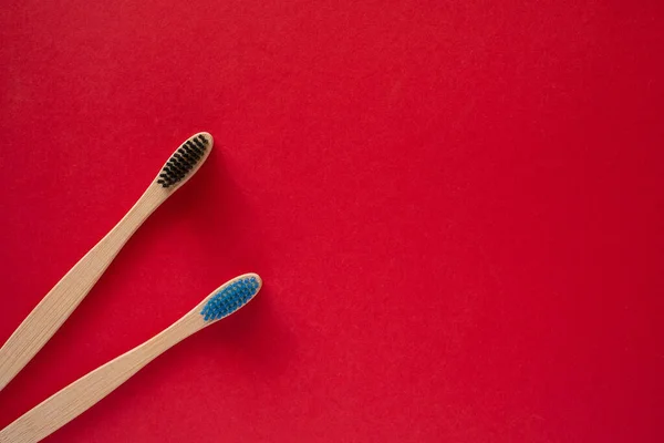 Eco wooden toothbrushes on isolated red background — Stock Photo, Image