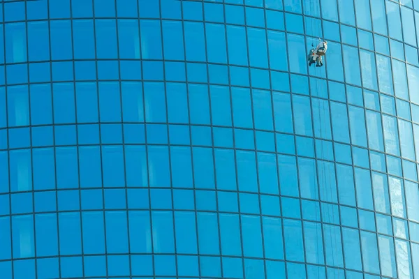 Industrial climber washes office building glasses