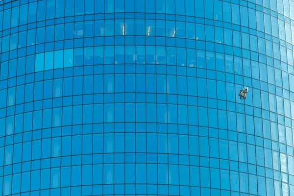 Industrial climber washes office building glasses