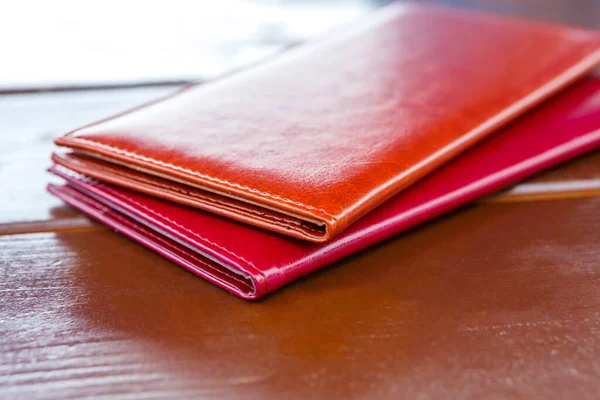 Leather folders for restaurant bills sit on a wooden table