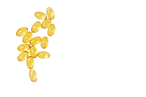 Vitamin D capsules scattered on a white background. Food additive