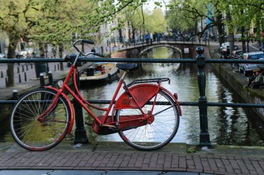 Yalnız kırmızı köprünün diğer tarafında kanal Amsterdam'da bisikletle resmini. 