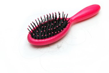 Pink hairbrush with some hair on it. Symbolises the hair loss of woman.  clipart
