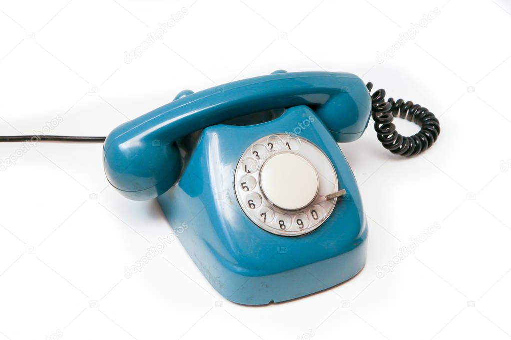 A blue old retro rotary mechanical phone isolated on a white background. 