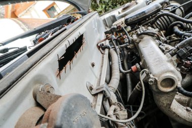 Eski araba enkazından bir ayrıntı. Motor buji ile. Petrol sızıntısı var. 