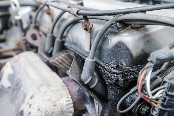 Eski araba enkazından bir ayrıntı. Motor buji ile. Petrol sızıntısı var. 